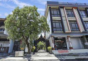 a building with a tree in front of it at Moreno Homestay in Legian