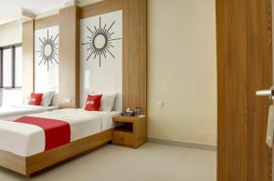 a bedroom with two beds with red pillows at Moreno Homestay in Legian