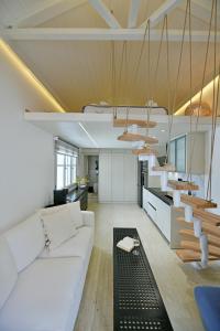 a living room with a white couch and a kitchen at Pearl House in Hydra