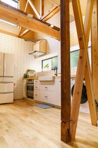 an open kitchen with white appliances and wooden beams at Spacious 80m2 Private House, central Tokyo in Tokyo