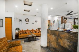 a man standing at a bar in a room at Hotel Seven in Chandīgarh