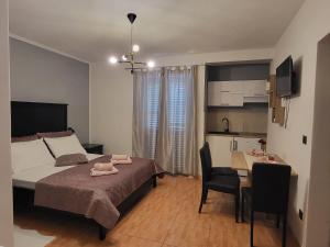 a bedroom with a bed and a table and a kitchen at E&A in Baška Voda