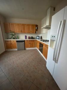 a kitchen with wooden cabinets and a white refrigerator at Maison luxe entier a Limay in Limay