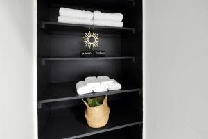 a closet with black shelves and white towels at Urban Loft 2-story 1BR Near DT on Historic Street in Columbus