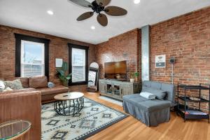 a living room with a couch and a brick wall at Urban Loft 2-story 1BR Near DT on Historic Street in Columbus