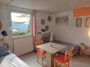 a room with a table and a bed and a window at HAUT JURA 