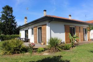 a small house with a porch and a yard at Seignosse : Mandago Surf Home in Seignosse