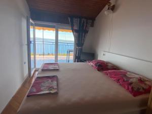 a bedroom with a large bed with a large window at Apartments Drazen in Crikvenica