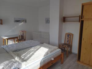 a bedroom with a bed and two chairs in it at Haus Sandra Ferienwohnung 2 in Dahme