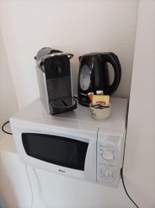 eine Mikrowelle mit einer Kaffeekanne darüber in der Unterkunft O'Couvent - Appartement 44 m2 - 1 chambre - rdc ext in Salins-les-Bains