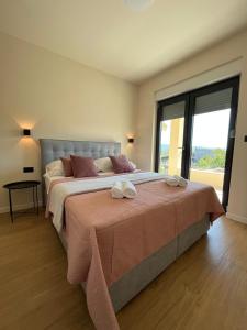 a bedroom with a large bed with a large window at Apartment Mate in Pridraga