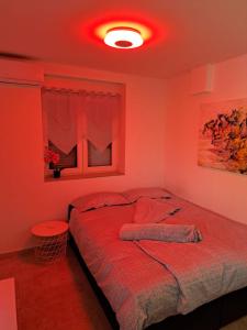 1 dormitorio con 1 cama con techo rojo en Near beach studio, en Kaštela