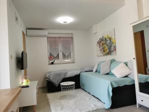 1 dormitorio con 2 camas y TV en Near beach studio, en Kaštela