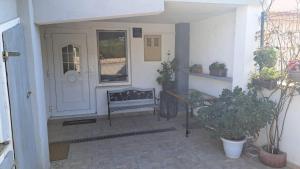 a porch with a table and a bench next to a door at Near beach studio in Kaštela