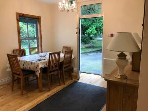 a dining room with a table and chairs and a lamp at Rose Cottage in Irvinestown