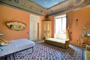 a bedroom with orange walls and a bed and a window at Al Massimo Piacere in Palermo