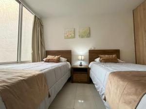 twee bedden naast elkaar in een slaapkamer bij Asiminas lovely house in Ixia