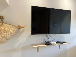 a flat screen tv hanging on a wall at Studio Pampa - Centre historique - Climatisation - WiFi in Grasse
