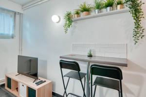 Pokój z biurkiem z 2 krzesłami i telewizorem w obiekcie MILANO - Studio à deux pas de l’Avenue du Prado w Marsylii