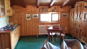 a kitchen with wooden walls and a table with chairs at Il Refuge CIR 119 in Courmayeur