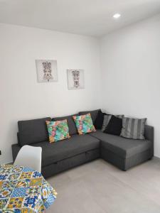 1 sofá en la sala de estar con 2 almohadas en I Mori di Brucoli en Brucoli
