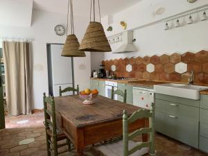 cocina con mesa de madera en una habitación en Cortijo El Triguero N-398 Ctra Carmona – El Viso del Alcor Km 18, en Carmona