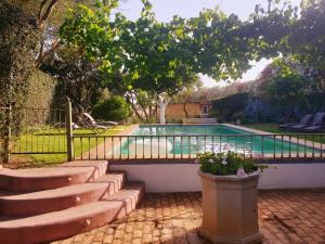 a swimming pool with a fence and some chairs at Cortijo El Triguero N-398 Ctra Carmona – El Viso del Alcor Km 18 in Carmona