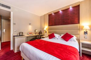 um quarto de hotel com uma cama grande e um cobertor vermelho em Hôtel Les Trois Roses, Meylan Grenoble The Originals Boutique em Meylan