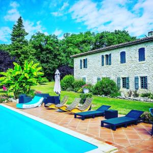 a backyard with chairs and a swimming pool at Chambres d'hotes Le Bernes in Vic-Fezensac