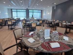 uma sala de jantar com mesas e cadeiras num restaurante em Domitys La Clef des Arts em Châlons-en-Champagne