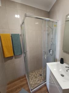 eine Dusche mit Glastür neben einem Waschbecken in der Unterkunft Casa Zeferino in Ferragudo