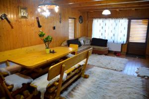 sala de estar con mesa de madera y sofá en Pensiunea "Vio Merisani ", en Merişani