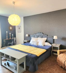- une chambre avec un grand lit doté d'un couvre-lit bleu dans l'établissement Chambres d'hotes Le Bernes, à Vic-Fezensac