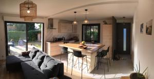 a kitchen and living room with a couch and a table at Seignosse : Mandago Surf Home in Seignosse