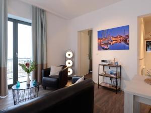 ein Wohnzimmer mit einem Sofa und einem Stuhl in der Unterkunft Ohlerich Speicher App. 19 - Meerblick in Wismar