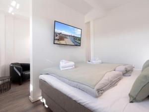 a bedroom with a bed with a tv on the wall at Ohlerich Speicher App. 19 - Meerblick in Wismar