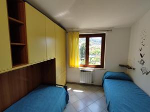 ein kleines Zimmer mit 2 Betten und einem Fenster in der Unterkunft Anfitrite Tortolì in Àrbatax