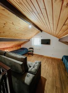 a living room with wooden ceilings and a couch at Apartamentos Dumont in Monte Verde