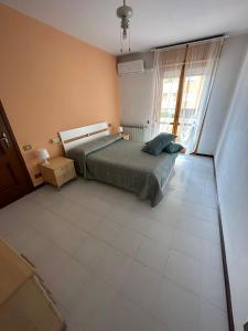 een slaapkamer met een bed en een grote tegelvloer bij Appartamento ALICE (CISANELLO-PISA) in Pisa