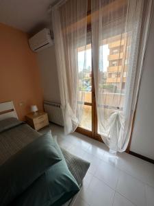 een slaapkamer met een bed en een groot raam bij Appartamento ALICE (CISANELLO-PISA) in Pisa