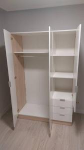 a white closet with white shelves in a room at apartamento a 19min de Gijón y 15 de Oviedo in Langreo