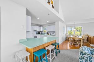 a kitchen and dining room with a blue counter and chairs at Cherished Memories in Nags Head