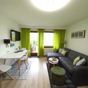 Erholungs- Apartment am Kurpark & Thermen Bad Urach في باد أوراش: غرفة معيشة مع أريكة وطاولة