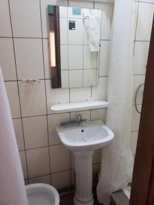 La salle de bains est pourvue d'un lavabo, d'un miroir et de toilettes. dans l'établissement RÉSIDENCE TCHAMS, à Yaoundé