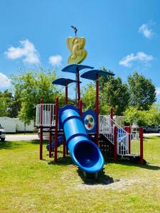 a playground with a blue slide in a park at Bumgalow 5X in Pataias