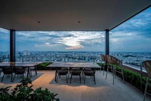 d'une terrasse avec tables et chaises et vue sur la ville. dans l'établissement The Rixx Iconic Apartment @ D1/pool/gym/Netflix, à Hô-Chi-Minh-Ville