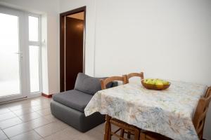 a dining room table and a chair with a bowl of fruit on it at Apartment Silvana in Senj