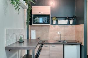 a small kitchen with a table and a microwave at MILANO - Studio à deux pas de l’Avenue du Prado in Marseille