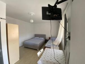 een kleine kamer met een bed en een tv aan de muur bij Cathrin’s villas and apartments in Zverneci