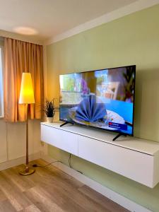 uma sala de estar com uma grande televisão de ecrã plano na parede em FeWo Sunshine em Heringsdorf